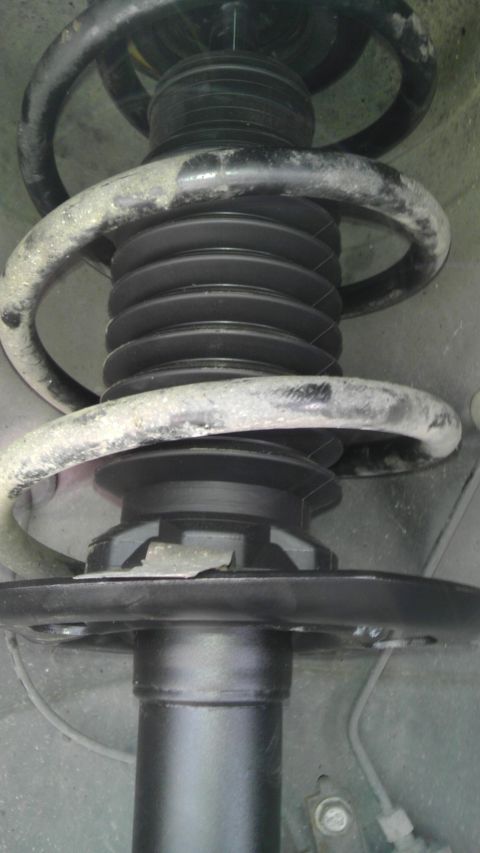 2007 Dodge Caliber - Close-up of a vehicle's front strut assembly, showing the coil spring and dust boot.