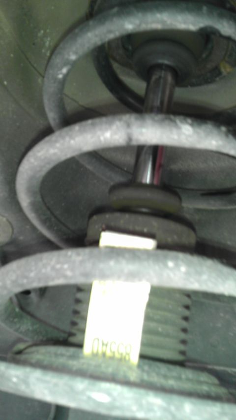 2007 Dodge Caliber - A close-up view of a car's suspension system, showing a yellow tag with part number information.
