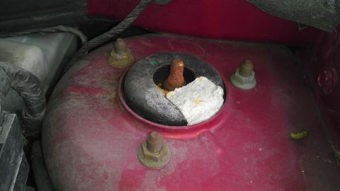 2007 Dodge Caliber - Close-up of a rusted strut mount, possibly from a car's engine bay, with white packing material.