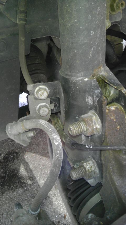 2007 Dodge Caliber - Detail of a vehicle's suspension system, focusing on the brake line and strut mount.