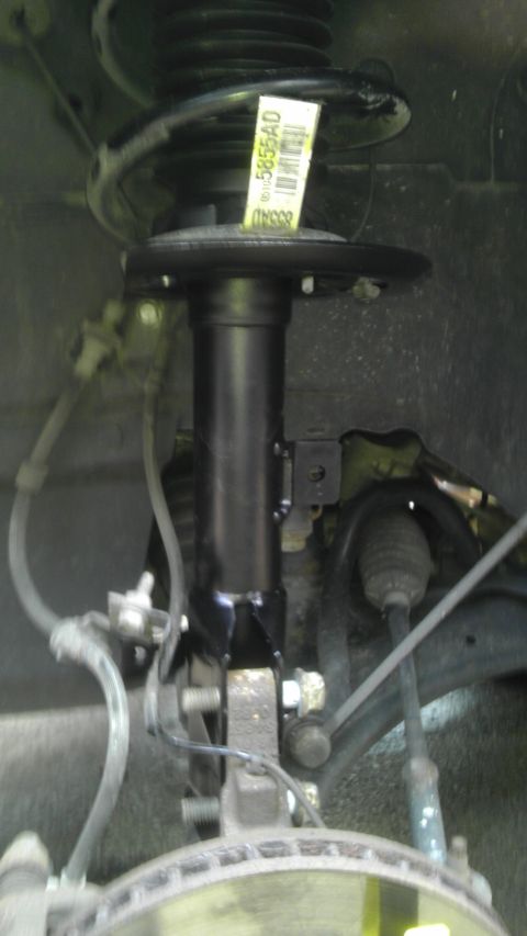 2007 Dodge Caliber - Close-up view of a vehicle's front suspension strut and coil spring assembly.