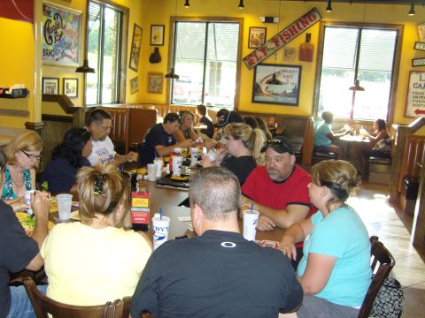 2007 Ford Mustang - A group of people are gathered around tables in a restaurant, enjoying a meal together.