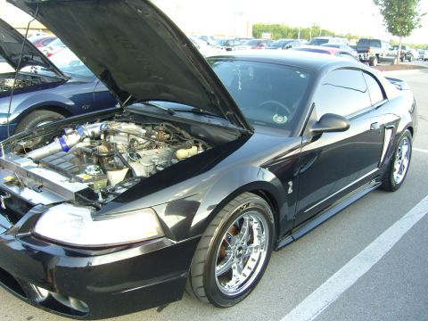2007 Ford Mustang - A black Ford Mustang is parked with its hood open, revealing the engine compartment.