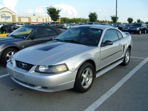 2007 Ford Mustang - Silver Ford Mustang parked in a lot with a Kroger store in the background.