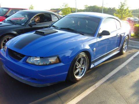 2007 Ford Mustang - A blue 2007 Ford Mustang is parked in a lot next to a black car.