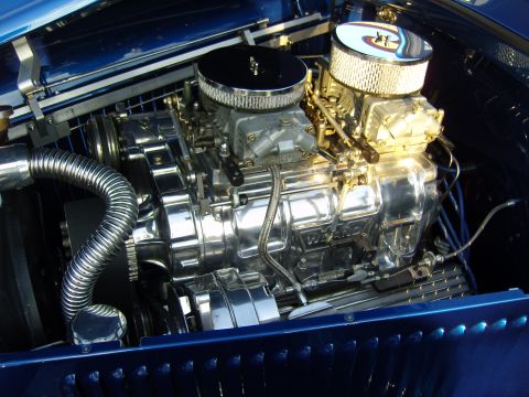 2007 Ford Mustang - A highly polished V8 engine with a Weiand supercharger and dual carburetors is visible under the hood of a blue vehicle.