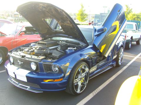 2007 Ford Mustang - A blue Ford Mustang with custom doors and racing stripes is displayed with its hood open.