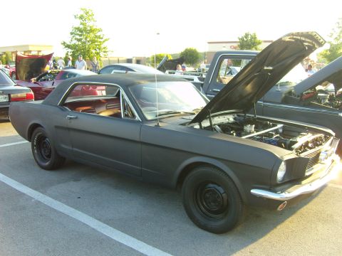 2007 Ford Mustang - Matte black 1966 Ford Mustang coupe at a car meet, hood open showing the engine bay.