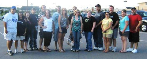 2007 Ford Mustang - A group of people pose for a photo in a parking lot with several vehicles visible.