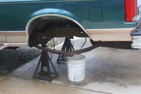 1996 Ford Bronco - Rear suspension work on a 1996 Ford Bronco, leaf spring removed and vehicle on jack stands.