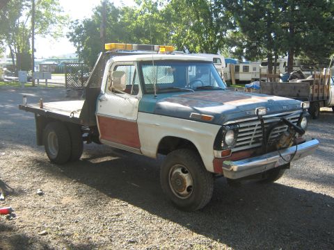 1972 Ford F-250 - This 1972 Ford F-250 flatbed truck features a unique three-tone paint scheme and a heavy-duty winch mounted on the front bumper.