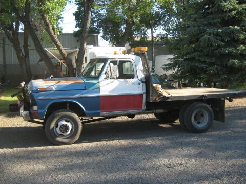 1972 Ford F-250 - This 1972 Ford F-250 flatbed tow truck has a distinctive red, white, and blue paint scheme.