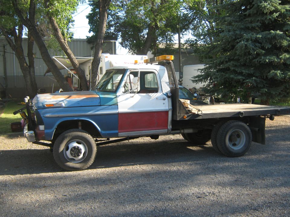 1972 Ford F-250 flatbed tow truck with a multi-color paint job