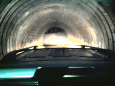 1985 Ford LTD Crown Victoria - Driving through a tunnel, the exit light is visible ahead.