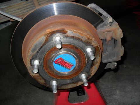 1990 Ford Bronco - The brake assembly, including the rotor and caliper, shows significant rust and wear.