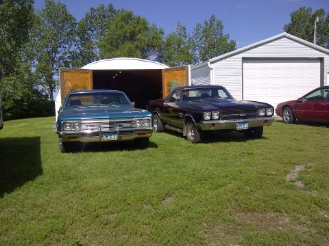 1994 Ford F-150 - A teal 1967 Chevrolet pickup and a dark El Camino are parked outside a garage.
