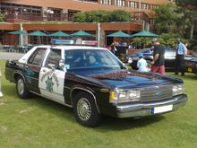 1991 Ford LTD Crown Victoria - This 1991 Ford Crown Victoria police car is parked on a lawn in front of a building.