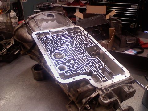 1996 Ford Bronco - A transmission valve body, disassembled for service, reveals its complex internal pathways.