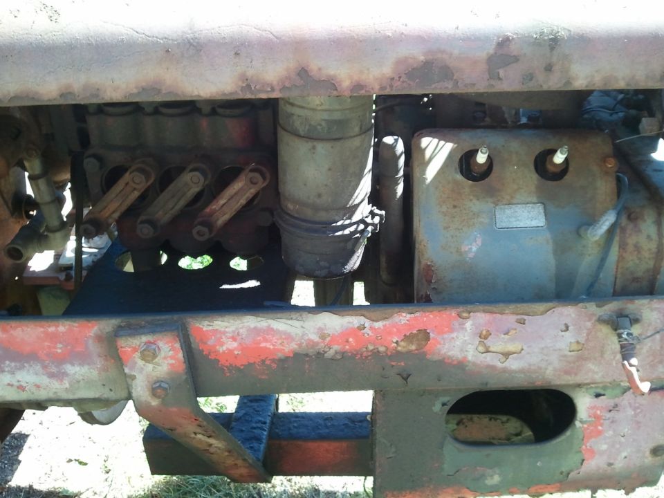 Close-up of a rusty tractor engine with visible spark plugs and valve train