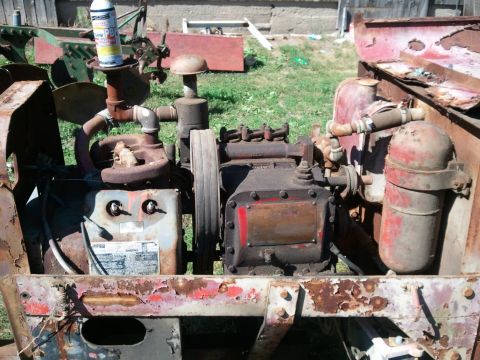 1985 Ford F-150 - Close-up of a corroded engine and pump assembly, showing pipes, filters, and a can of lubricant.