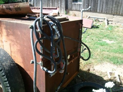 1985 Ford F-150 - A rusted sprayer tank with multiple hoses and gauges is shown outdoors.