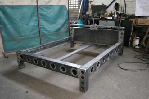 1973 Ford Ranchero - A heavy-duty metal bed frame is shown in a workshop, with tools and equipment in the background.