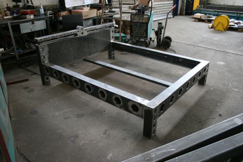 1973 Ford Ranchero - A raw metal bed frame sits in a workshop, awaiting further fabrication or assembly.