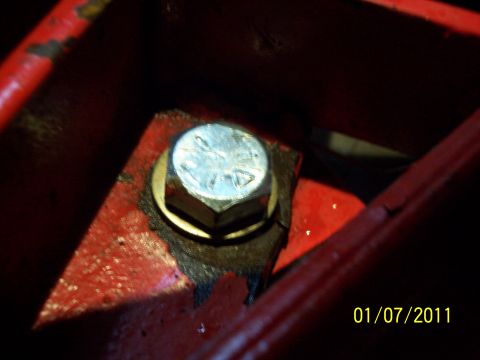 1973 Ford F-250 - A bolt secures a part on a red painted surface, with a date stamp and website visible in the corner.