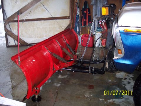 1973 Ford F-250 - A blue and chrome truck is equipped with a large red snow plow.