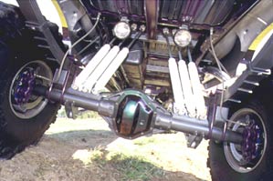 1992 Ford Bronco - Underside view of a heavily modified rear axle and suspension system on a lifted vehicle.
