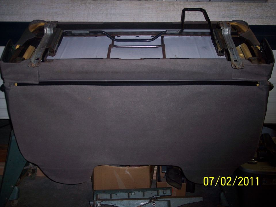 Gray cloth bench seat upside down showing slider rails and black tube support hoop