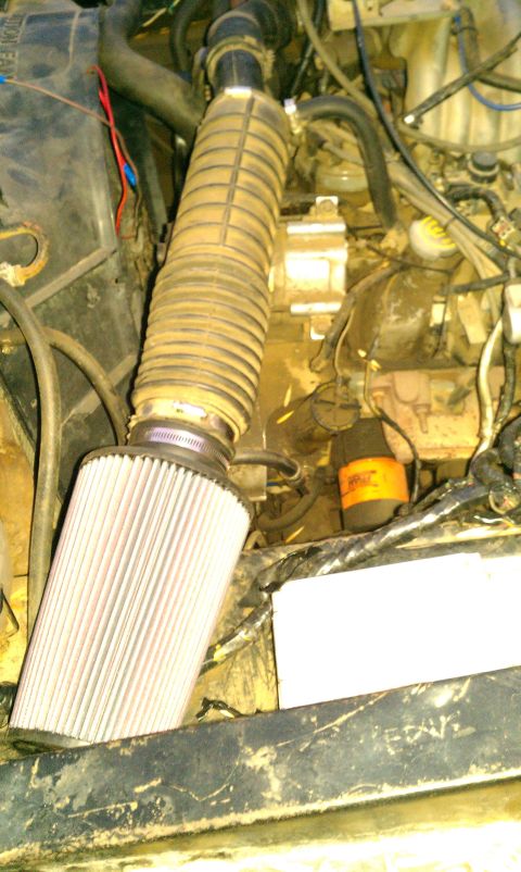1969 Ford F-250 - Aftermarket air filter installed in the engine bay, connected via a flexible hose to the intake system.