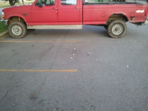 1985 Ford F-150 - This red pickup truck appears to be from the early to mid-1990s.