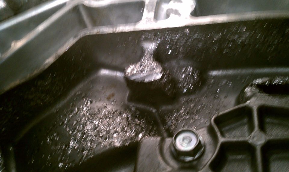 Damaged metal part with debris and a bolt. Supermotors.net logo visible
