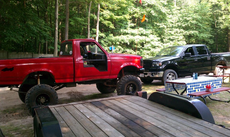 Red 1994 Ford F-250 pickup truck with lifted suspension and off-road tires