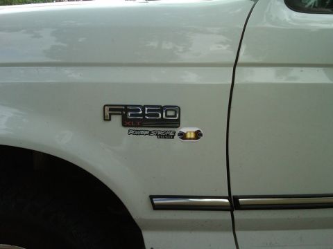1994 Ford Bronco - Close-up of a white Ford F-250 XLT Power Stroke Diesel badge on the fender.