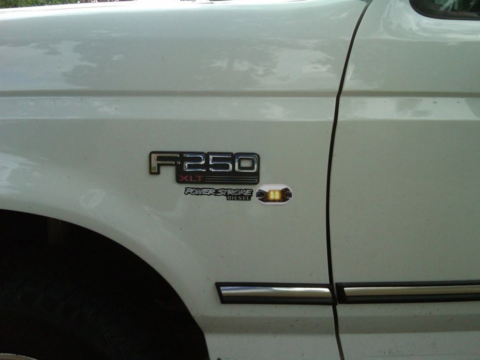 White Ford F-250 XLT Power Stroke Diesel fender badge with amber marker light