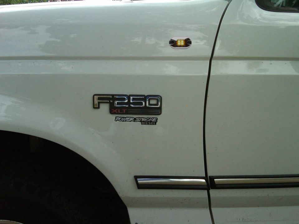 F-250 XLT Power Stroke Diesel fender badge on a white Ford pickup