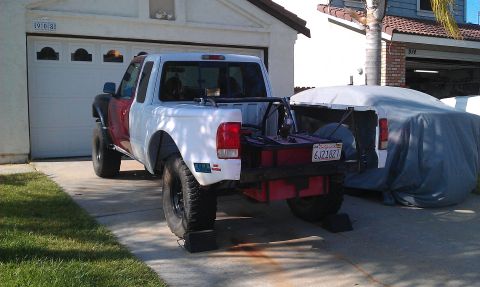 1992 Ford Ranger - A pickup truck with a red front fender and white rear is parked in a driveway next to a covered vehicle.