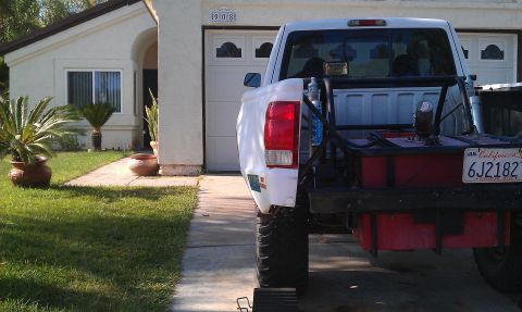 1992 Ford Ranger - Rear view of a white pickup truck modified with a large auxiliary fuel tank and roll cage, parked in a driveway.