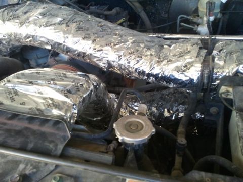 1995 Ford Bronco - The engine bay is covered in reflective insulation, obscuring most of the components.