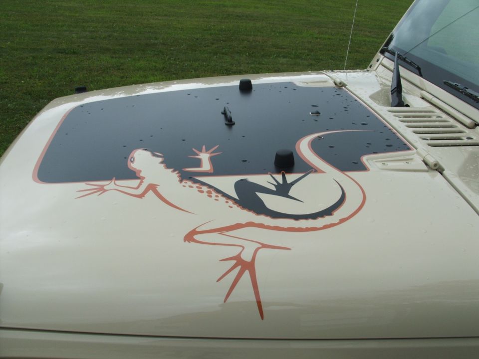Beige Jeep hood with black and orange lizard decal