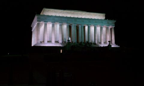 1990 Ford Bronco - The Lincoln Memorial stands illuminated against the night sky, with visitors gathered on its steps.