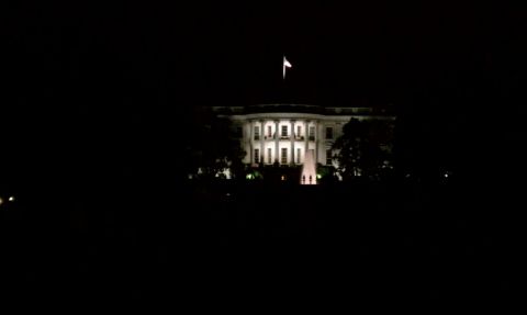 1990 Ford Bronco - Night shot of the illuminated north facade of the White House with a flag flying above and the lawn fountain lit below; no vehicle is visib…