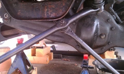 1990 Ford Bronco - Close-up view of a vehicle's rear axle assembly supported by jack stands and wooden blocks.