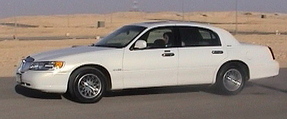 2002 Lincoln Town Car - A white 2002 Lincoln Town Car is shown from the side in a desert environment.