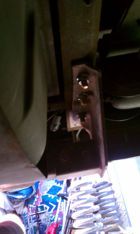 1990 Ford Bronco - Underside view of vehicle frame components, including a suspension spring and exhaust system.