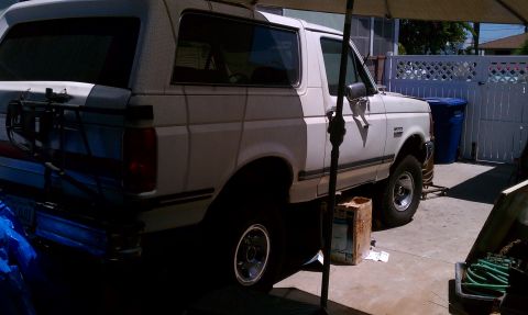 1990 Ford Bronco - This 1990 Ford Bronco is parked in a driveway with a spare tire carrier mounted on the back.