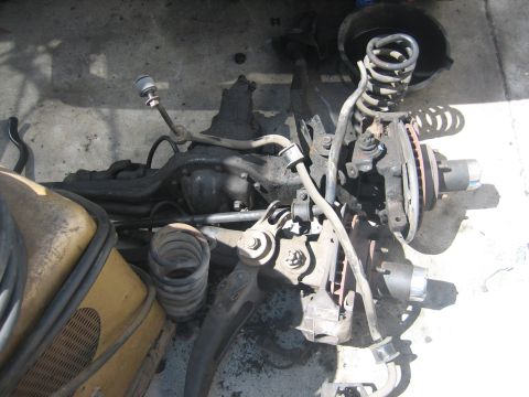1990 Ford Bronco - Front suspension components, including springs and brake assemblies, are laid out on the ground.