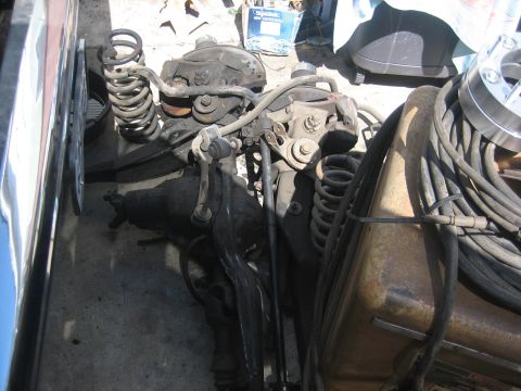 1990 Ford Bronco - Close-up view of automotive front suspension and differential parts, including springs and linkages.